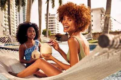 two women sitting in a hammock by a pool at 1435 Brickell Ave 3004 in Miami