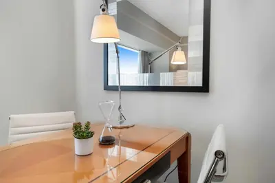 a dining room table with a lamp and a mirror at 1435 Brickell Ave 3004 in Miami
