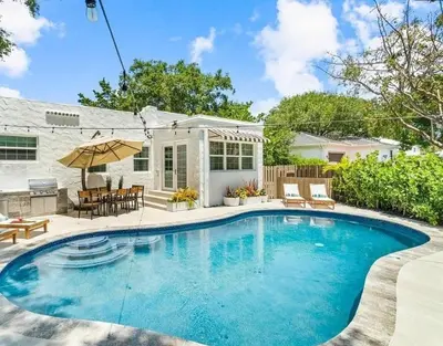 a swimming pool in front of a house at Rio Vista Prestige on Las Olas Heated Pool in Fort Lauderdale