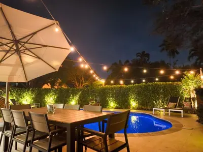 a table with chairs and an umbrella next to a pool at Rio Vista Prestige on Las Olas Heated Pool in Fort Lauderdale