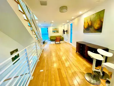 a living room with a staircase with chairs and a table at 16 GUESTS LUXURIOUS SOUTH BEACH SUITE WITH ROOFTOP 2 in Miami Beach