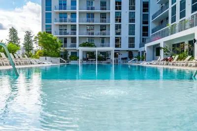 a large swimming pool in front of a building at Prime Location 1-Bed Retreat With Free Parking in Miami