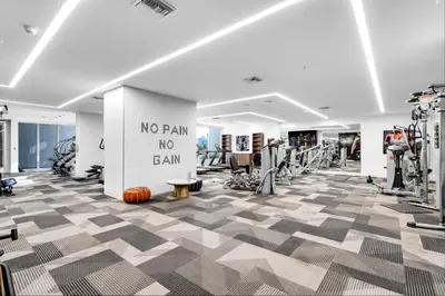 a gym with a no pain no gain sign on a wall at Prime Location 1-Bed Retreat With Free Parking in Miami