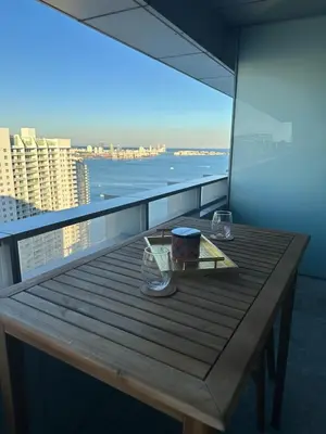 a table on a balcony with a view of the ocean at Brickell 31th Floor Sea View Free Parking by Palermo Home Miami in Miami