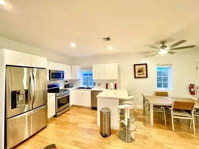 a kitchen with a stainless steel refrigerator and a table at 20 GUESTS LUXURIOUS SOUTH BEACH SUITE 2 in Miami Beach