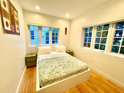 a bedroom with a bed and two windows at 60 Guests Luxury South Beach Private Estate in Miami Beach