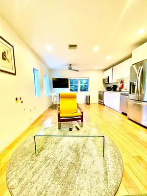 a living room with a yellow chair and a glass table at 60 Guests Luxury South Beach Private Estate in Miami Beach