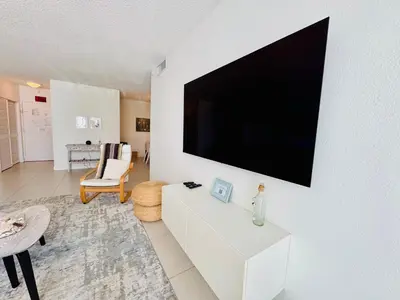 a living room with a flat screen tv on a wall at Special $$$! 2 Bedroom Oceanfront Condo in Hollywood/Hallandale Beach! in Hollywood