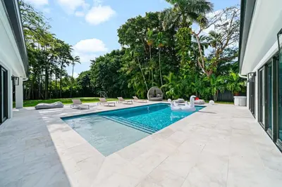 a swimming pool in a yard with chairs and trees at Luxury Villa Azure with Heated Pool 20 minutes to Beach in Miami