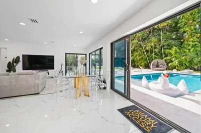 a living room with a pool and a table and chairs at Luxury Villa Azure with Heated Pool 20 minutes to Beach in Miami