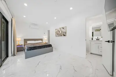a white bedroom with a bed in a room with marble floors at Luxury Villa Azure with Heated Pool 20 minutes to Beach in Miami