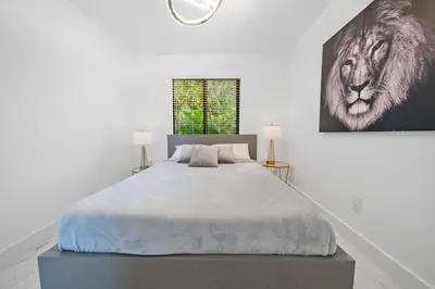a bedroom with a large bed with a lion picture on the wall at Luxury Villa Azure with Heated Pool 20 minutes to Beach in Miami