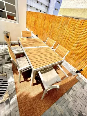 a wooden table and chairs in front of a wall at 30 GUESTS LUXURY SOUTH BEACH SUITES w ROOFTOP in Miami Beach