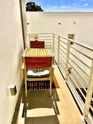 a wooden bench sitting on top of a balcony at 30 GUESTS LUXURY SOUTH BEACH SUITES w ROOFTOP in Miami Beach