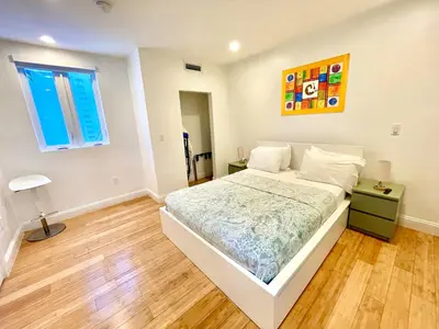 a white bedroom with a bed and a window at 30 GUESTS LUXURY SOUTH BEACH SUITES w ROOFTOP in Miami Beach