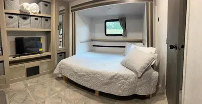 a small bedroom with a bed and a tv at Free BBQ in RV With Private entrance in Homestead