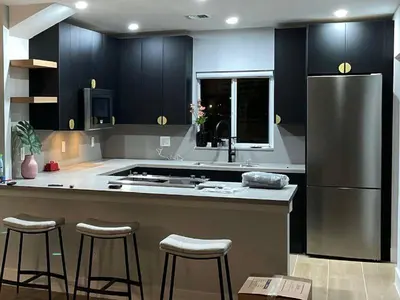 a kitchen with black cabinets and a stainless steel refrigerator at Stylish Room close to everything in Miami in Miami Shores