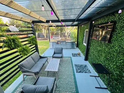 an outdoor patio with couches and chairs and a wall at Stylish Room close to everything in Miami in Miami Shores
