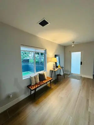 an empty living room with a bench and a window at Stylish Room close to everything in Miami in Miami Shores