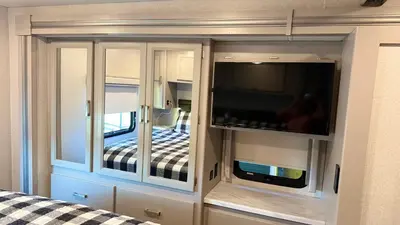 a living room with a tv and a bedroom at Private Cozy R/V , for your enjoyment in Tamiami