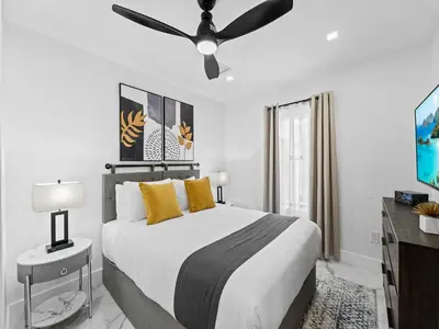 a bedroom with a bed with a ceiling fan at Spacious home w heated pool jacuzzi in Hollywood