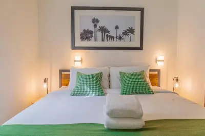 a bedroom with a bed with green and white pillows at 1-Bed Apt with rooftop pool Ocean Dr by the Beach B207 in Miami Beach