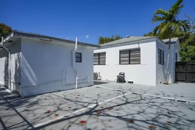 a white house with two garage at Sri House in Miami