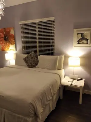 a bedroom with a large white bed with two lamps at M HOTEL in Miami Beach