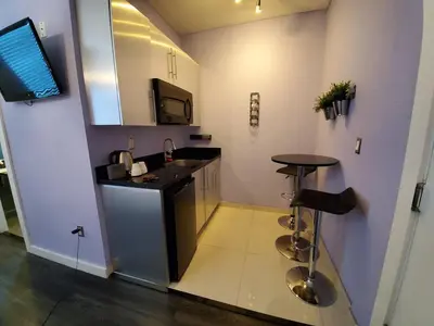 a kitchen with a counter and a sink and a stool at M HOTEL in Miami Beach