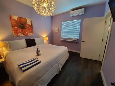 a bedroom with a large white bed and a chandelier at M HOTEL in Miami Beach