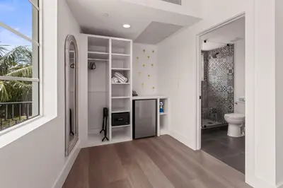 a white bathroom with a toilet and a window at Casa SOBE in Miami Beach