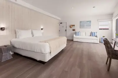 a bedroom with a large white bed and a couch at Casa SOBE in Miami Beach