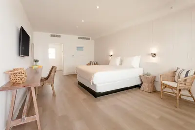 a bedroom with a white bed and a table and chairs at Casa SOBE in Miami Beach