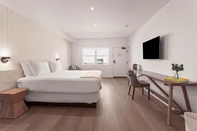 a bedroom with a bed and a desk and a television at Casa SOBE in Miami Beach