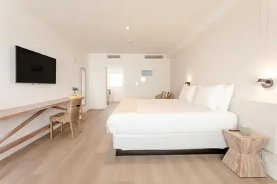 a white bedroom with a large bed and a tv at Casa SOBE in Miami Beach