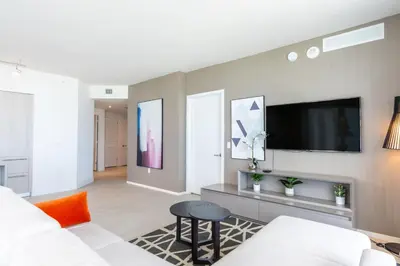 a living room with a white couch and a tv at Amazing Pools Luxury 2Br Front Ocean Bay View in Hollywood