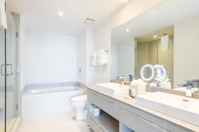 a bathroom with two sinks and a toilet and a mirror at Amazing Pools Luxury 2Br Front Ocean Bay View in Hollywood