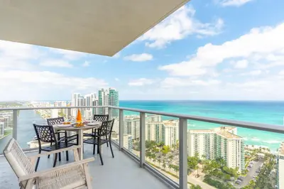 a balcony with a table and chairs and the ocean at Amazing Pools Luxury 2Br Front Ocean Bay View in Hollywood