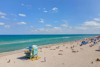 a beach with a crowd of people and the ocean at Ocean Drive Prime Apt w/2 Queen-Beds, South Beach in Miami Beach