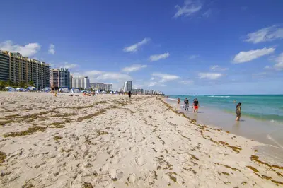 a group of people walking on the beach at Ocean Drive Prime Apt w/2 Queen-Beds, South Beach in Miami Beach