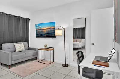 a living room with a couch and a desk with a laptop at Executive Studio Suite Hollywood Beach Blvd in Hollywood
