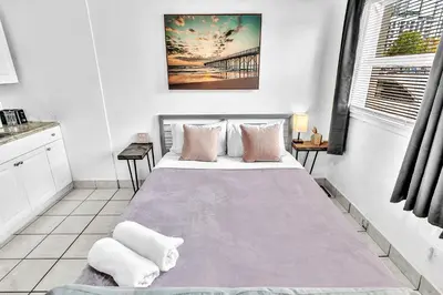 a bedroom with a large bed with pink pillows at Executive Studio Hollywood Blvd & Near Beach in Hollywood