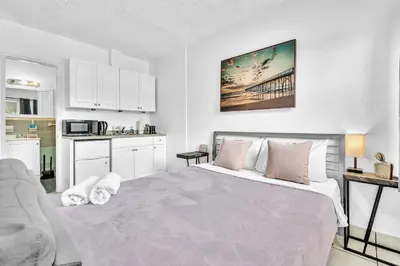 a white bedroom with a bed and a kitchen at Executive Studio Hollywood Blvd & Near Beach in Hollywood