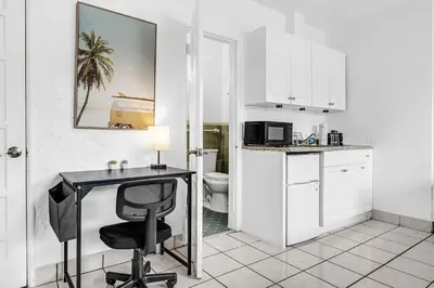 a white kitchen with a desk and a chair at Executive Studio Hollywood Blvd & Near Beach in Hollywood