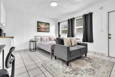 a bedroom with a bed and a couch and a chair at Executive Studio Hollywood Blvd & Near Beach in Hollywood