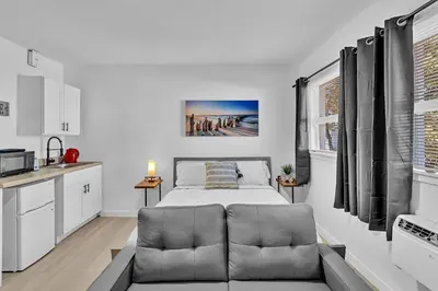 a bedroom with a bed and a couch in a room at Hollywood Blvd Near The Beach 