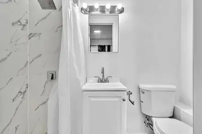 a white bathroom with a toilet and a sink at Hollywood Blvd Near The Beach 