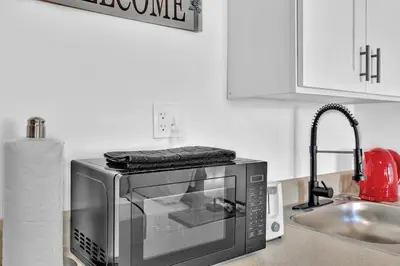 a microwave sitting on a kitchen counter next to a sink at Hollywood Blvd Near The Beach 