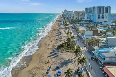 an aerial view of a beach with palm trees and the ocean at Hollywood Blvd Near The Beach 