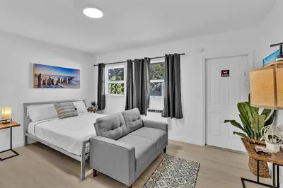 a white bedroom with a bed and a couch at Young Circle & Hollywood Blvd Posh Studio Suite in Hollywood
